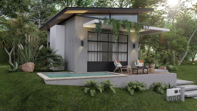 Modern small house with a front porch, outdoor seating area with two chairs, small table, potted plant, swimming pool, lush greenery, and stamped concrete steps leading up to the entrance, with sunlight filtering through trees.