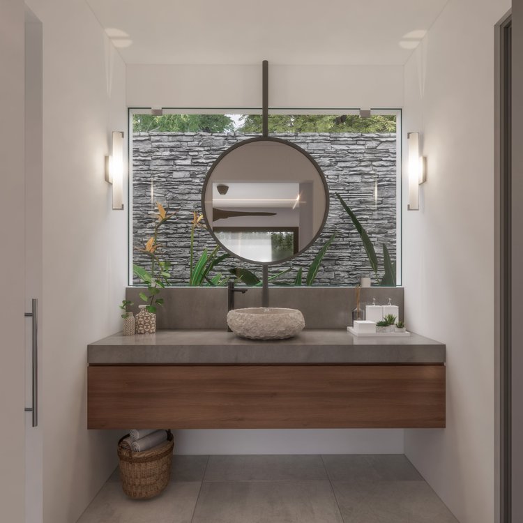 Modern bathroom vanity with a round mirror, stone sink, plants, and decorative items, with an outdoor stone wall visible through the window.