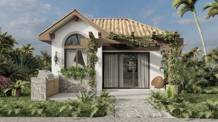 Modern house with arched window and sliding glass door, surrounded by lush greenery and tropical plants, under a partly cloudy sky.