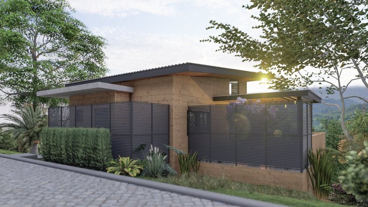 A modern house with beige walls, a flat overhanging roof, and black horizontal fence panels surrounded by lush greenery, with the sun shining through trees in the background.